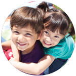 A young boy and girl with big smiles.