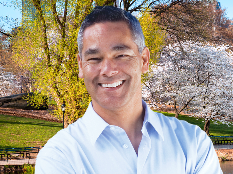 A man smiles in the park.